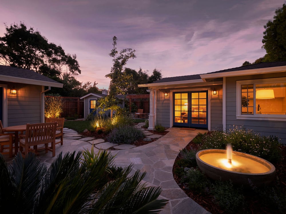 adu garden exterior at dusk with illuminated fountain and patio by mak design build in davis ca