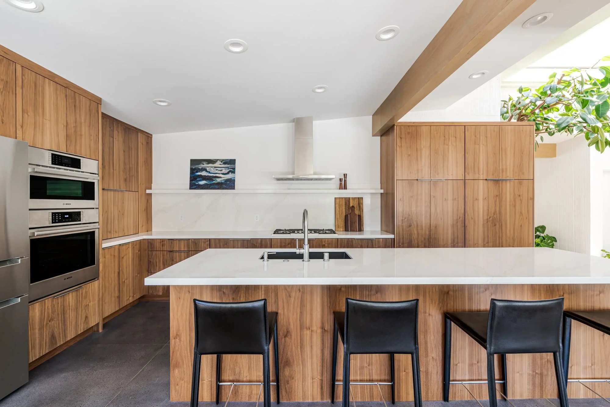 Modern kitchen with wood cabinetry, large island, and bar seating in Sacramento by MAK Design + Build Modern kitchen with wood cabinetry, large island, and bar seating in Sacramento by MAK Design + Build