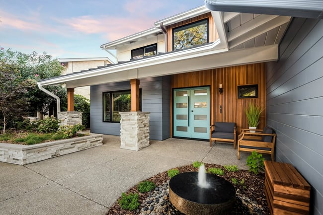 Modern home exterior with wood accents, covered porch, and entryway in Sacramento by MAK Design + Build