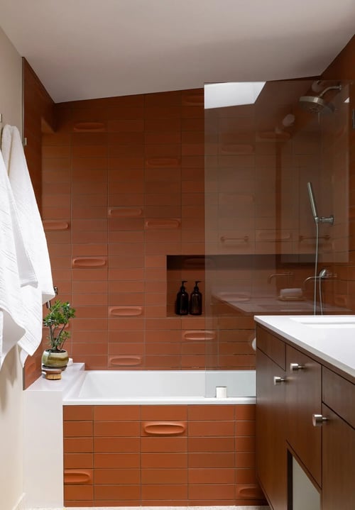 Modern bathroom with wood cabinetry, white tub, and glass shower in Sacramento by MAK Design + Build